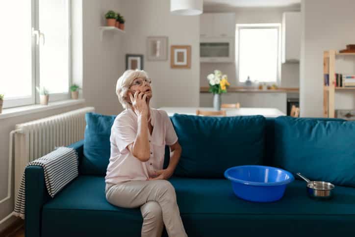 Older woman looking at ceiling while on phone.