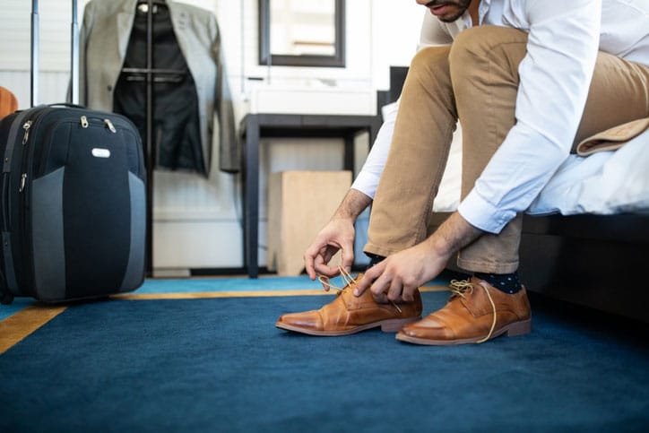Man Putting On Shoes with Blue carpet