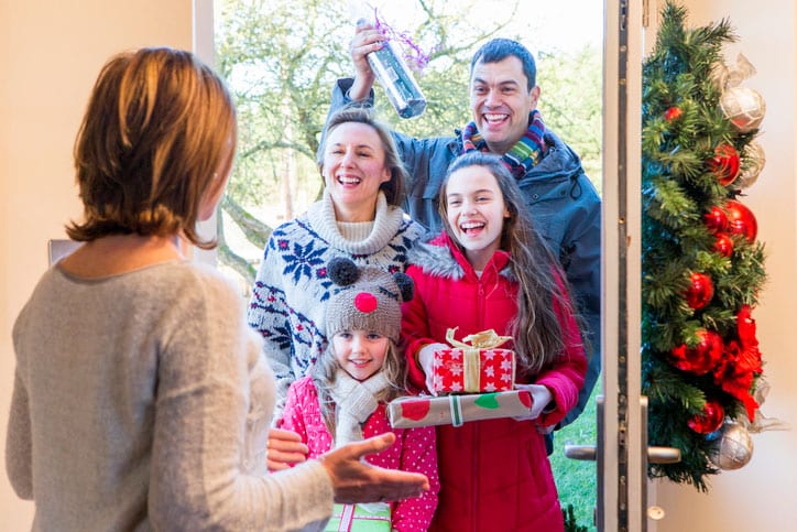 Woman Opening Door for Holiday Guests